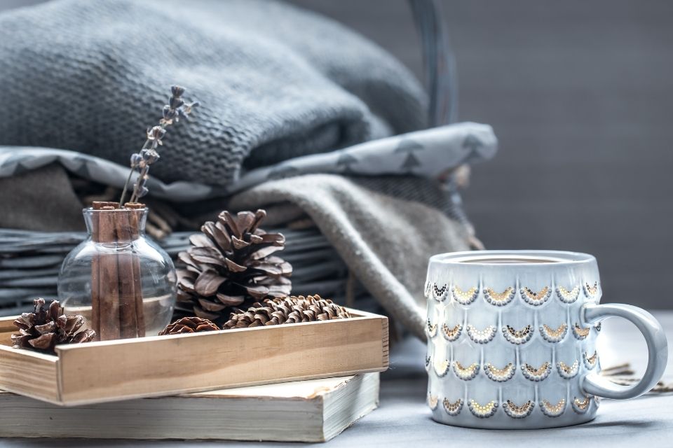 Close up photo of a coffee mug with a warm blanket